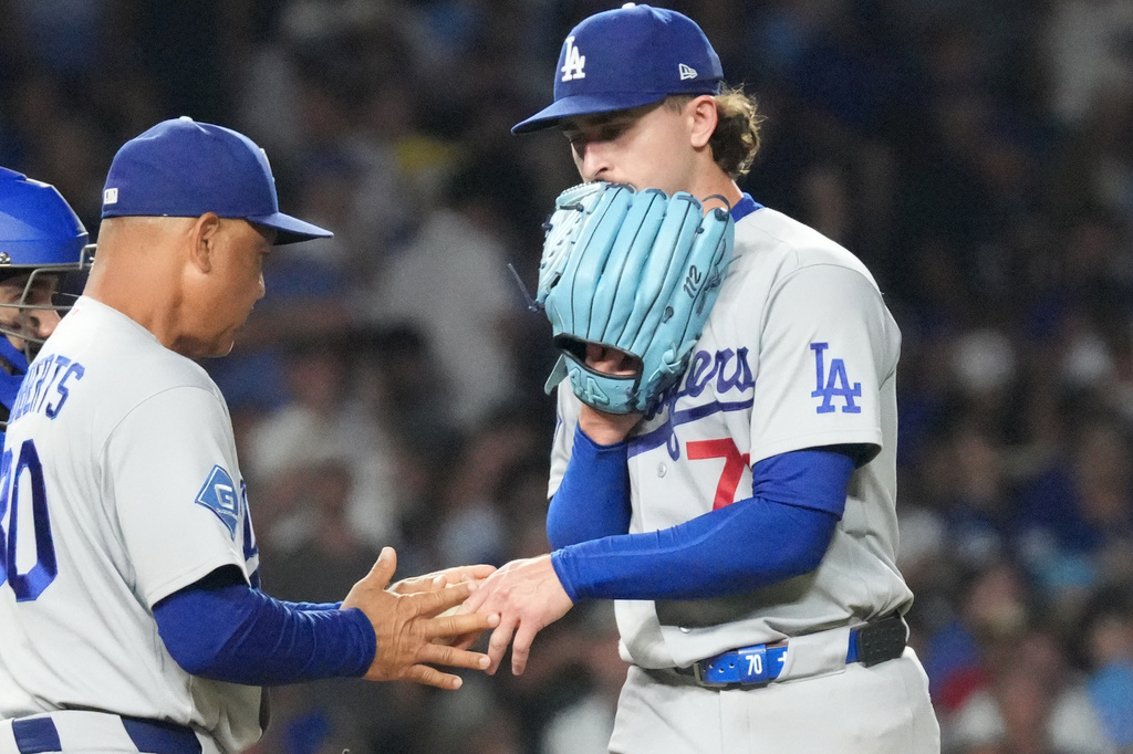 Los Angeles Dodgers pitcher Justin Wrobleski, right, gives the ball to manager Dave Roberts, front left, as he is taken out during the fifth inning of a baseball game against the Chicago Cubs, Monday, Aug. 3, 2026, in Chicago. (AP Photo/David Banks)