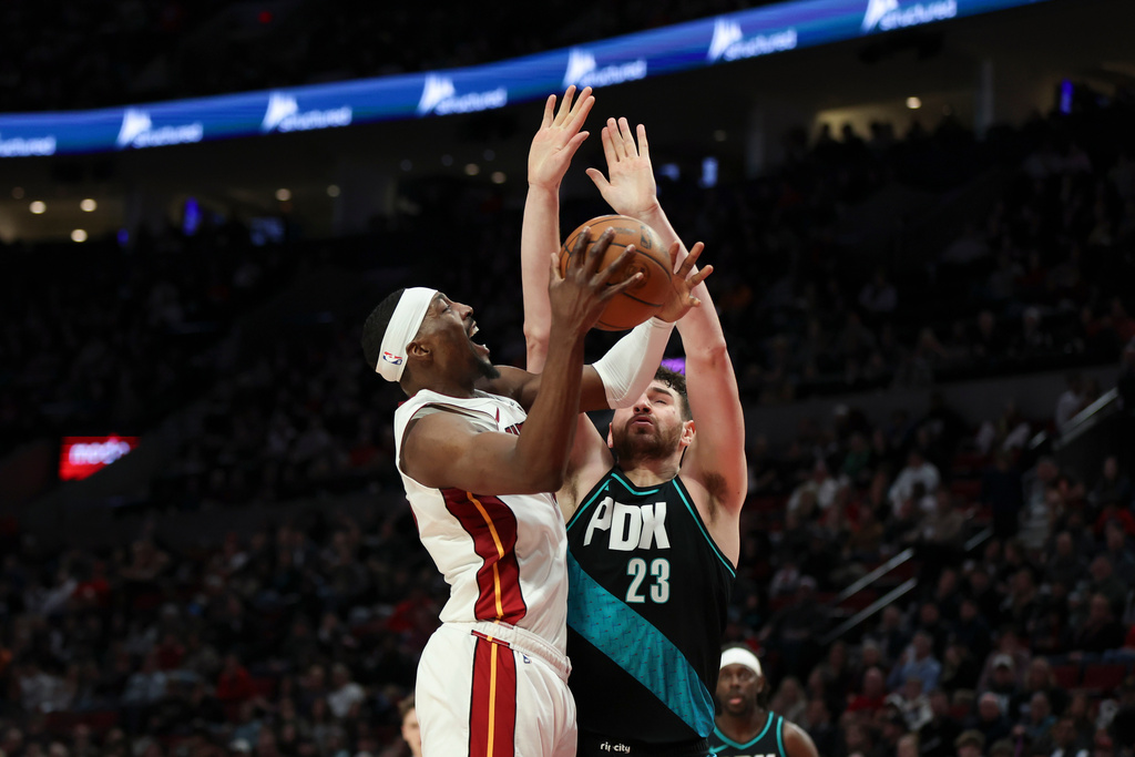 Miami Heat center Bam Adebayo, left, drives to the basket as Portland Trail Blazers center Donovan Clingan (23) defends during the first half of an NBA basketball game Thursday, Jan. 22, 2026, in Portland, Ore. (AP Photo/Amanda Loman)