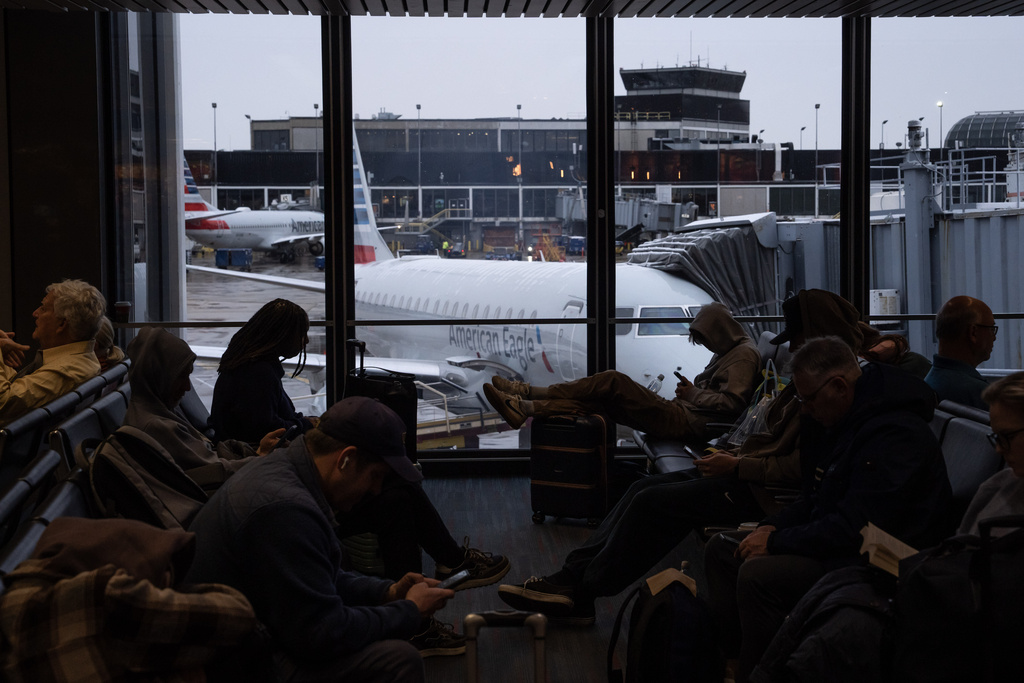 People wait for American Airlines flights at Chicago O'Hare International Airport in Chicago, Ill., Sunday, Nov. 9, 2025. (AP Photo/Adam Gray)