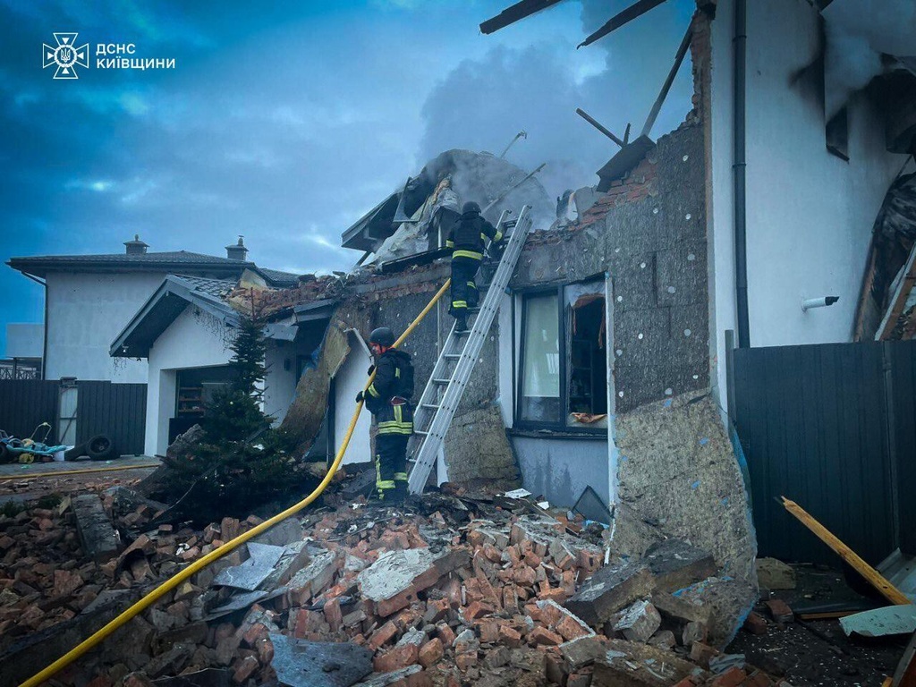 In this photo provided by the Ukrainian Emergency Service on Tuesday, Dec. 23, 2025, rescue workers put out a fire of a residential house destroyed by a Russian strike in Kyiv region, Ukraine. (Ukrainian Emergency Service via AP)