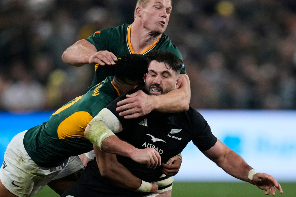 New Zealand's Luke Jacobson, right, is tackled by South Africa's Sacha Feinberg-Mngomezulu, left, and his teammate Pieter-Steph du Toit, during a third international test rugby match between South Africa and New Zealand, in Johannesburg, South Africa, Saturday, Sept. 5, 2026. (AP Photo/Themba Hadebe)