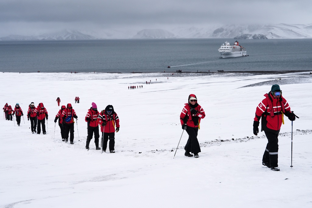 Passengers walk inside the volcano at Deception Island in Antarctica, Wednesday, Nov. 26, 2025. (AP Photo/Mark Baker)
