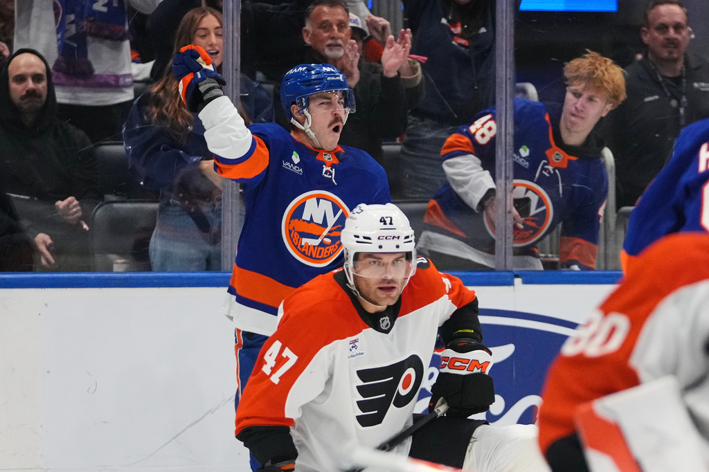 New York Islanders' Jean-Gabriel Pageau, left, celebrates after scoring a goal as Philadelphia Flyers' Noah Juulsen (47) reacts during the second period of an NHL hockey game Friday, April 3, 2026, in Elmont, N.Y. (AP Photo/Frank Franklin II)
