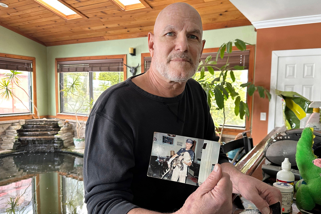 FILE - Tony Cavallaro holds a photo of his pet alligator, Albert, on March 19, 2024, in Hamburg, N.Y. (AP Photo/Carolyn Thompson, File)