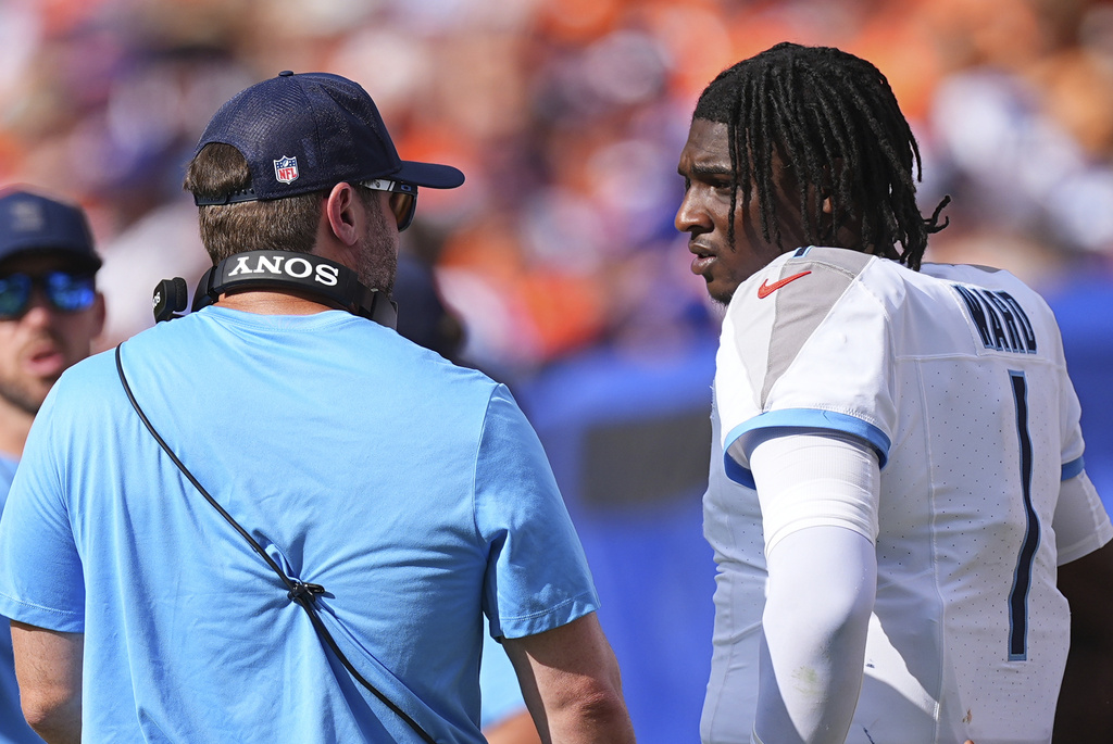 Tennessee Titans quarterback Cam Ward (1) speaks with head coach Brian Callahan, left, during the second half of an NFL football game against the Denver Broncos, Sunday, Sept. 7, 2025, in Denver. (AP Photo/David Zalubowski)