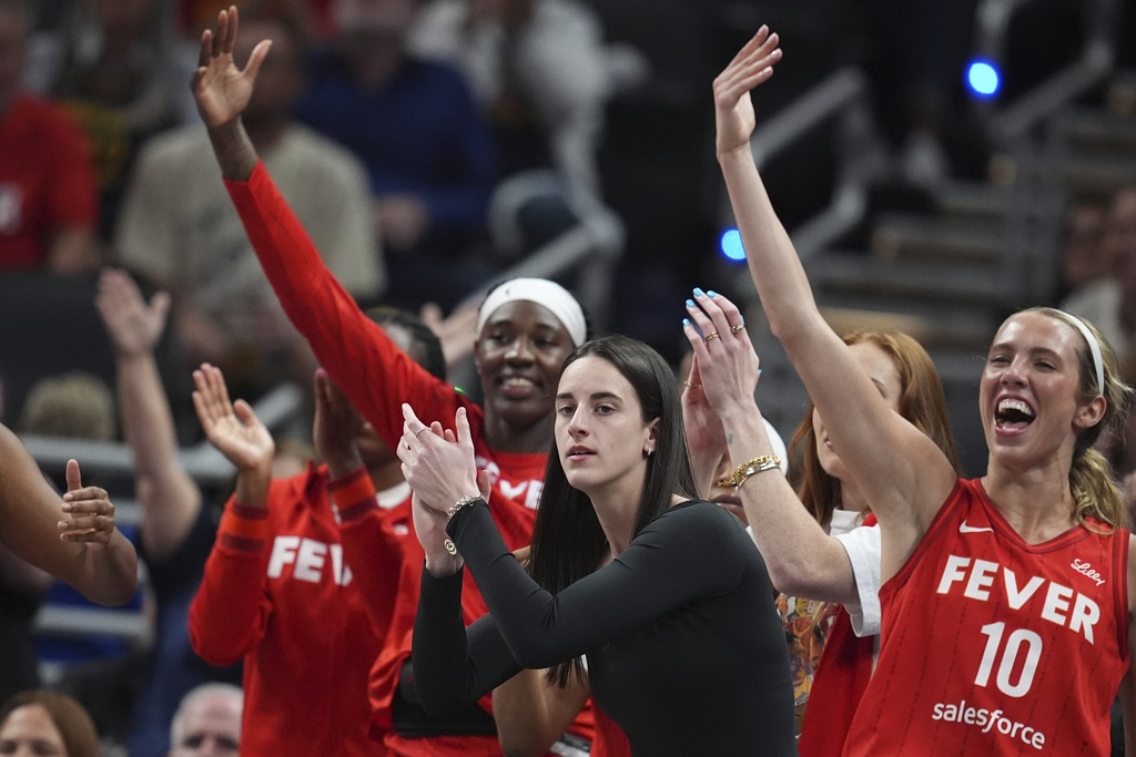 Indiana Fever's Caitlin Clark, middle, cheers during the first half of a WNBA basketball game against the Chicago Sky, Friday, Sept. 5, 2025, in Indianapolis. (AP Photo/Darron Cummings)