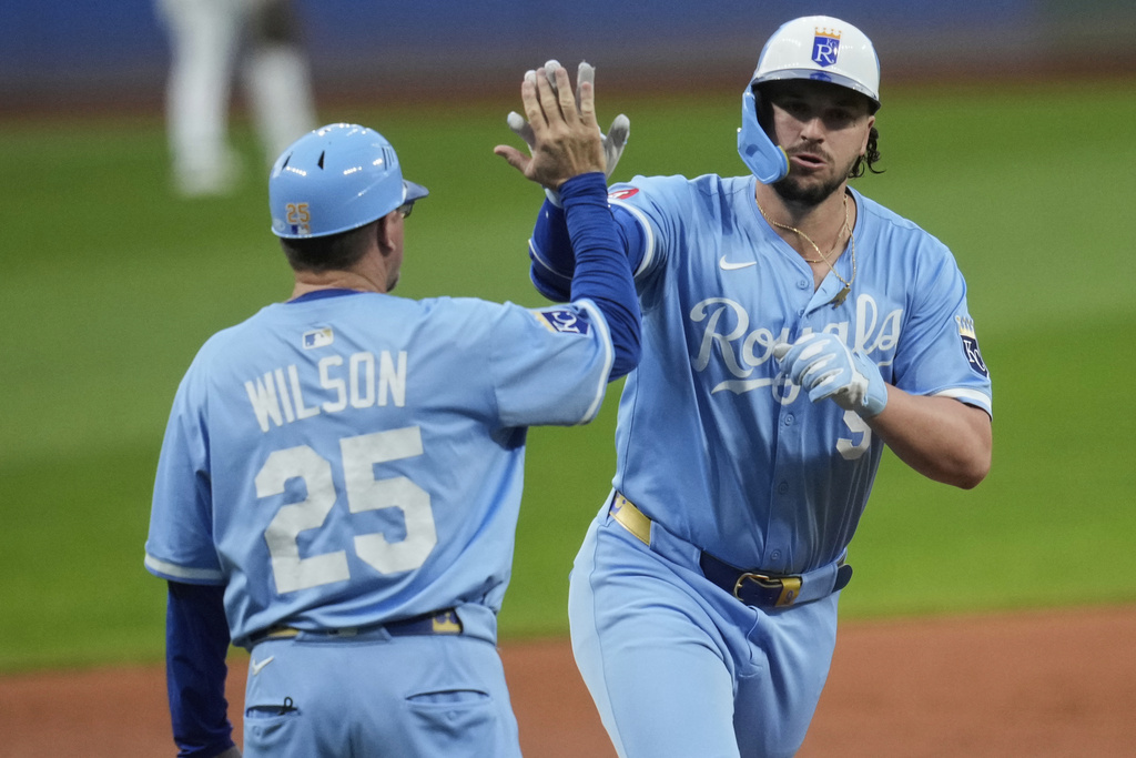 Kansas City Royals' Vinnie Pasquantino, right, is congratulated by major league field coordinator, third base coach Vance Wilson (25) as he rounds the bases after hitting a home run in the first inning of a baseball game in Cleveland, Thursday, Sept. 11, 2025. (AP Photo/Sue Ogrocki)