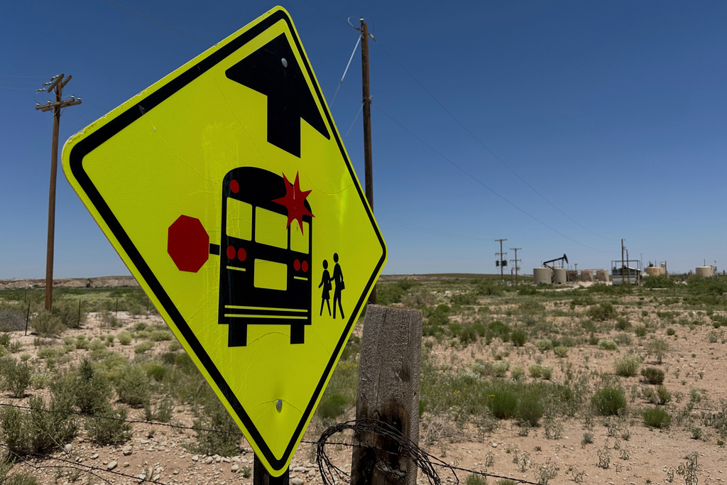 FILE - A sign warns drivers of a school bus stop near an oil field on the outskirts of Loving, N.M., May 19, 2025. (AP Photo/Susan Montoya Bryan, File)