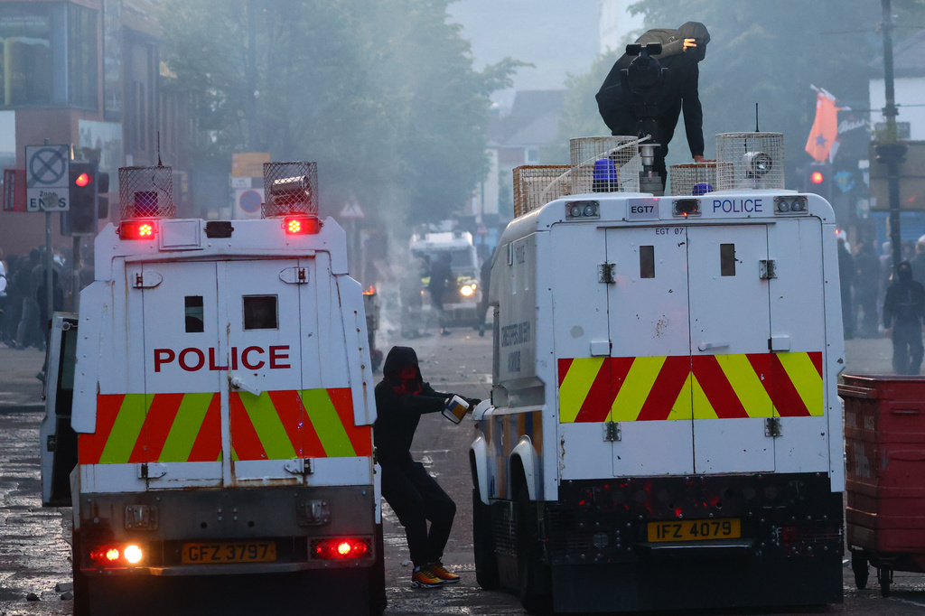 Police vehicles come under attack from protesters following a stabbing incident in Belfast, Tuesday, June 9, 2026. (AP Photo/Peter Morrison)