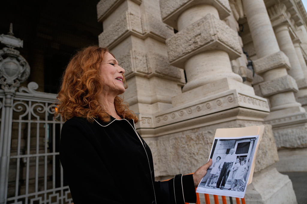 Karen Bonadio, from the United States, holds a picture of her and her grandfather Giuseppe Nicola Montesano, as she is interviewed by the Associated Press outside Italy's highest Court of Cassation, in Rome, Tuesday, April 14, 2026, prior to the start of a hearing to argue against the new citizenship law that restricts citizenship by descent. (AP Photo/Gregorio Borgia)