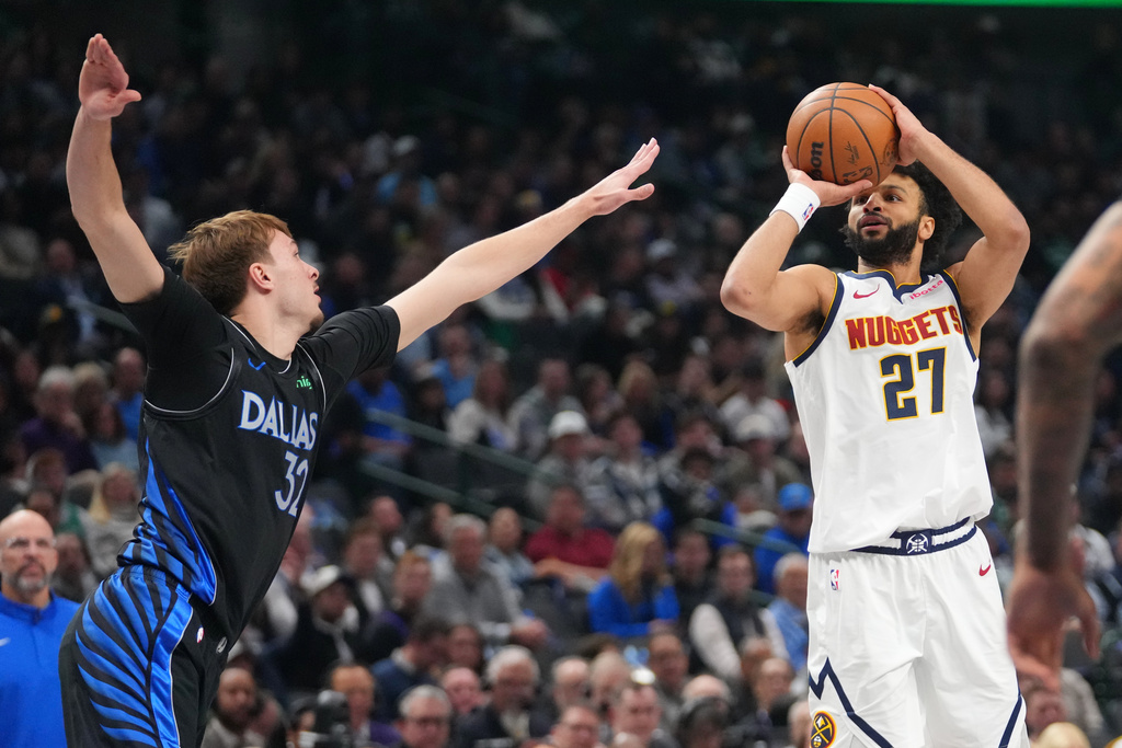 Denver Nuggets guard Jamal Murray (27) shoots a basket against Dallas Mavericks forward Cooper Flagg (32) during the first half of an NBA basketball game Wednesday, Jan. 14, 2026, in Dallas. (AP Photo/Julio Cortez)