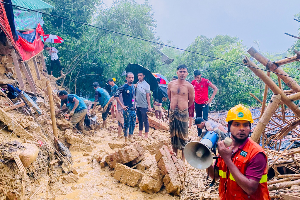Rescuers work at the site of a landslide at a Rohingya refugee camp in Cox's Bazar, Bangladesh, Wednesday, July 8, 2026. (AP Photo/Shamimul Islam Faisal)