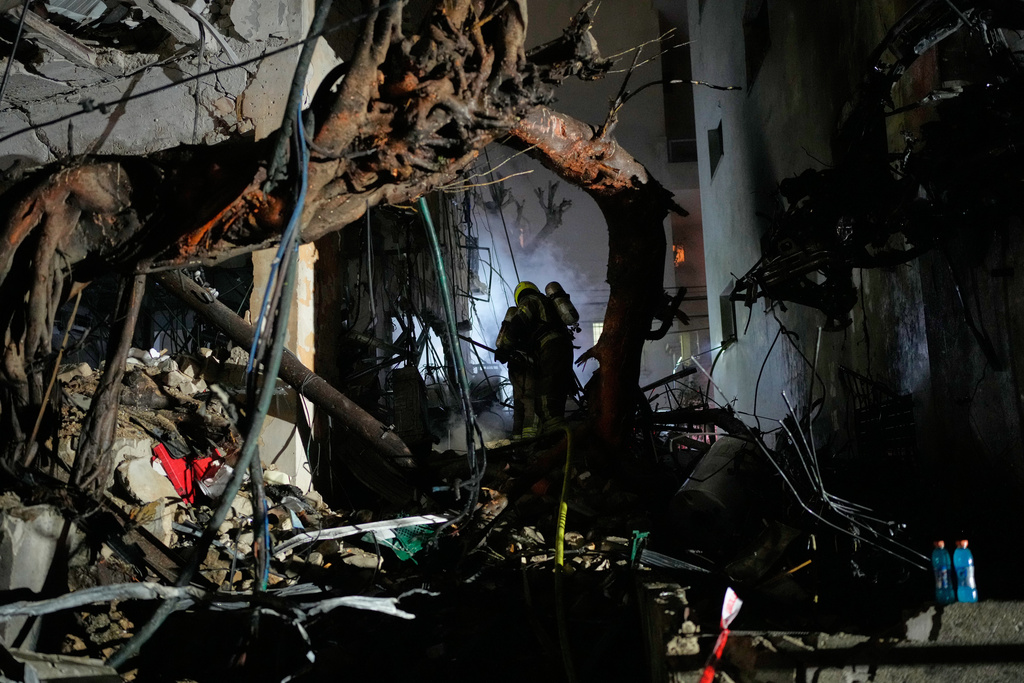 Officers from Israel's Home Front Command search through the rubble of a damaged apartment building after an Iranian missile strike in Tel Aviv, Israel, early Sunday, March 1, 2026. (AP Photo/Ohad Zwigenberg)