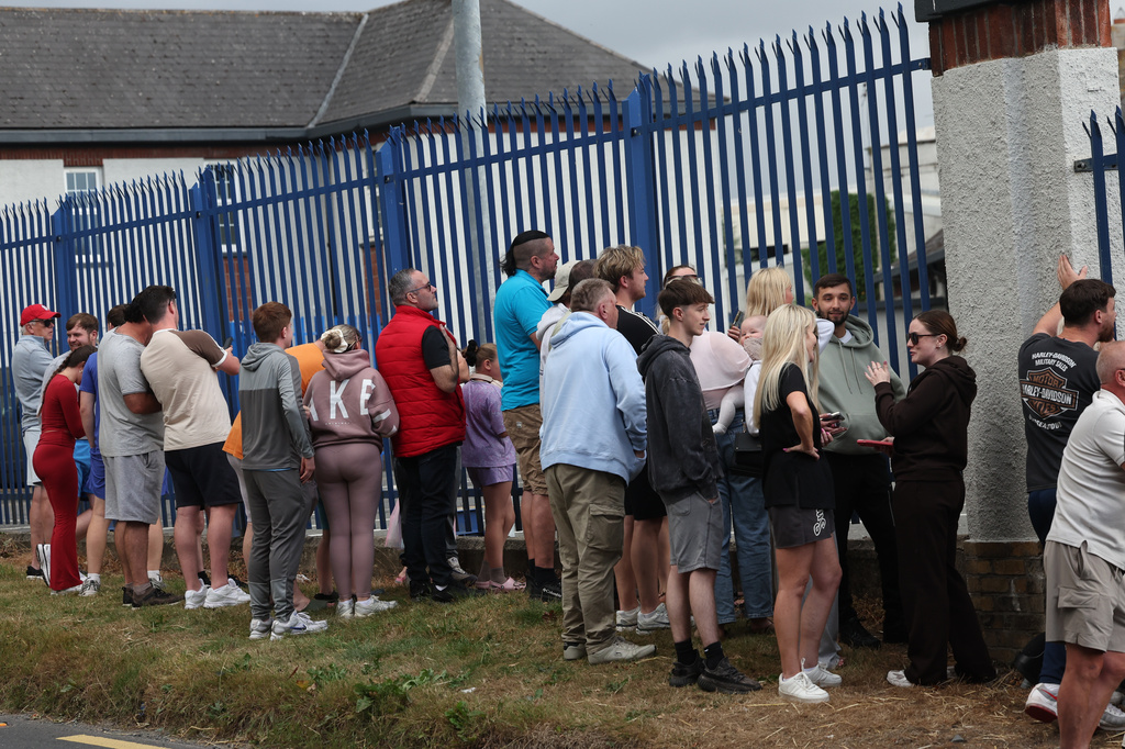 Members of the public outside Casement Aerodrome in Baldonnell, Ireland, Sunday, Aug. 9, 2026, where a Irish government plane believed to be carrying Daniel Kinahan landed, following him being extradited from Dubai, to face a charge of directing an organized crime group. (Damien Eagers/PA via AP)