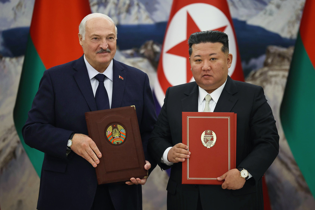 In this photo released by Belarus' Presidential Press Service, North Korea's leader Kim Jong Un, right, and Belarusian President Alexander Lukashenko hold signed documents during their meeting in Pyongyang, North Korea, Thursday, March 26, 2026. (Belarus' Presidential Press Service via AP)