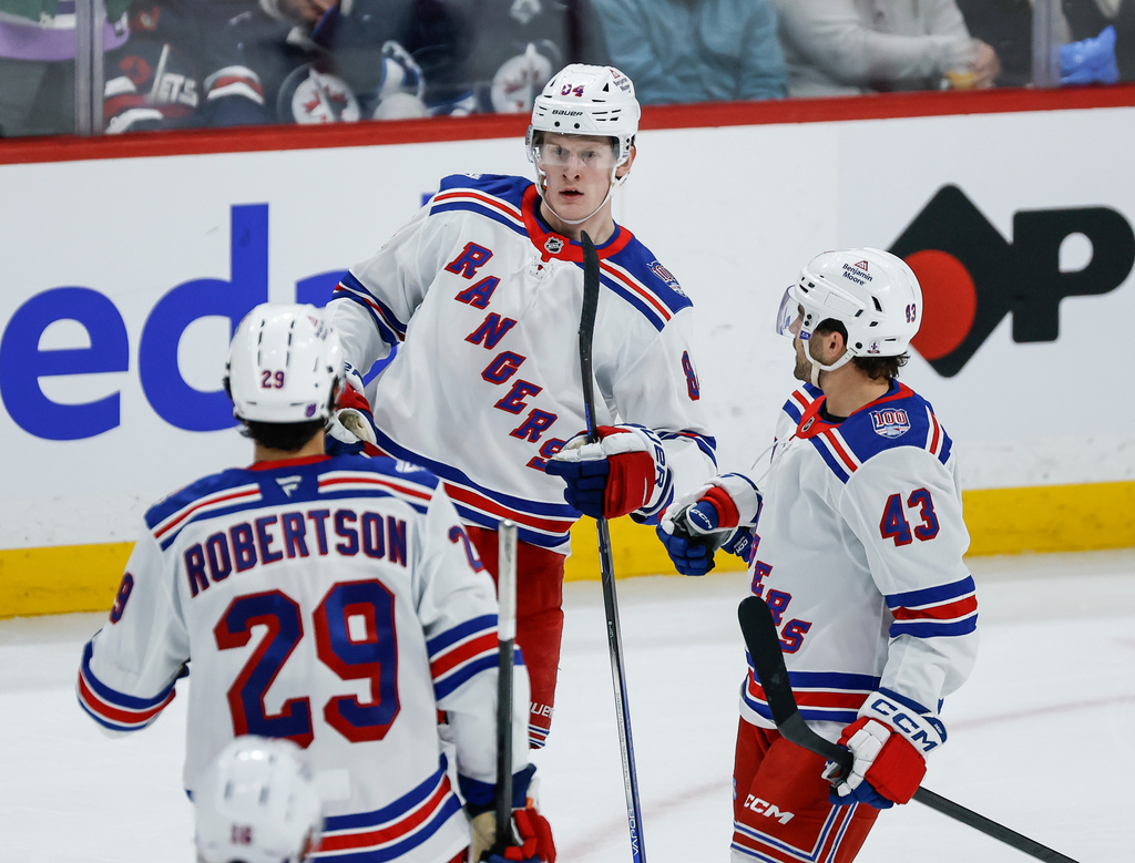 New York Rangers' Matthew Robertson (29), Gabe Perreault, center, and Conor Sheary (43) celebrate Perreault's goal against the Winnipeg Jets during the third period of an NHL hockey game in Winnipeg, Manitoba, Thursday, March 12, 2026 .(John Woods/The Canadian Press via AP)