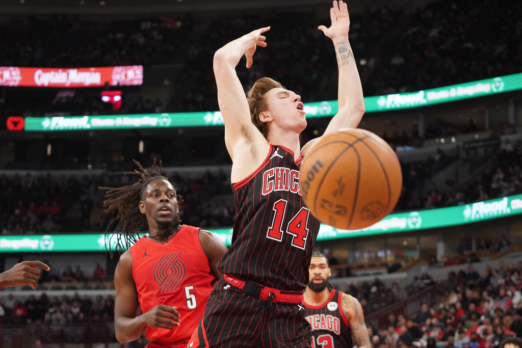 Chicago Bulls forward Matas Buzelis (14) is fouled by Portland Trail Blazers guard Jrue Holiday (5) during the second half in an NBA basketball game Thursday, Feb. 26, 2026, in Chicago. (AP Photo/David Banks)