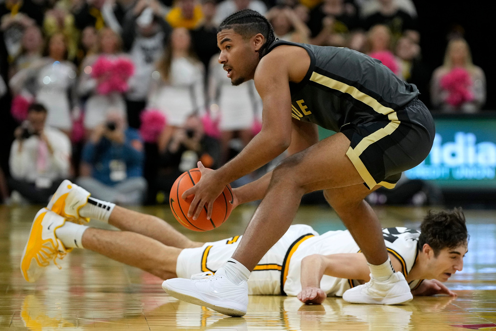 Purdue guard C.J. Cox, top, fights for the ball with Iowa guard Tate Sage, bottom, during the first half of an NCAA college basketball game, Saturday, Feb. 14, 2026, in Iowa City, Iowa. (AP Photo/Charlie Neibergall)