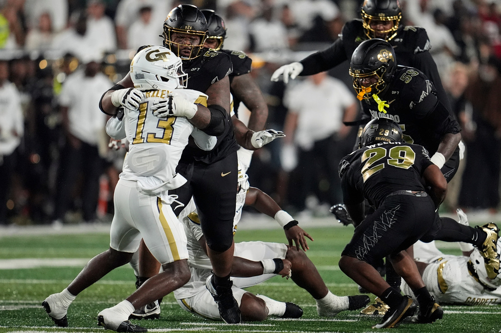Colorado offensive lineman Chauncey Gooden (51) blocks Georgia Tech safety Savion Riley (13) as Colorado running back Micah Welch (29) runs during the first half of an NCAA college football game, Thursday, Sept. 3, 2026, in Atlanta. (AP Photo/Mike Stewart)