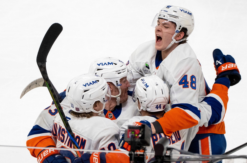 New York Islanders' Jean-Gabriel Pageau (44) celebrates after his winning goal with teammates Simon Holmstrom (10), Casey Cizikas, second from left, and Matthew Schaefer (48) during overtime NHL hockey game action in Montreal, Thursday, Feb. 26, 2026. (Christinne Muschi/The Canadian Press via AP)
