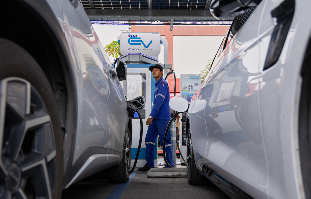 Khatawut Junsongsaeng, a charging station manager, walks past two Chinese-made electric vehicles at a parking lot in Bangkok, Thailand on June 4, 2026. (AP Photo/Anton L. Delgado)