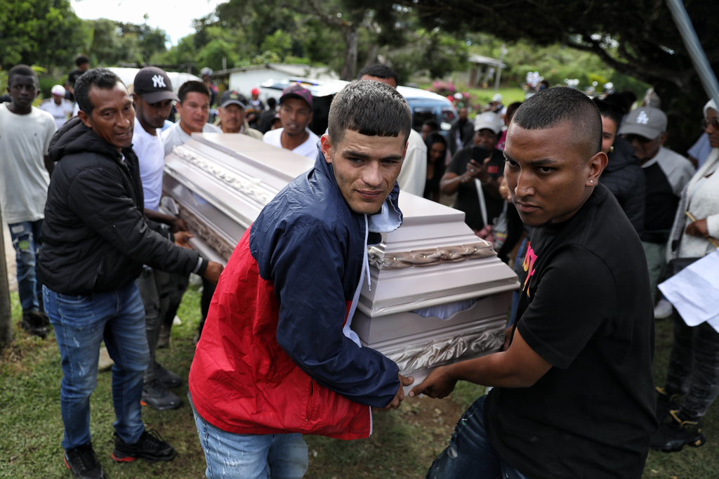 Relatives of a victim of an attack that killed at least 20 people on the Pan-American Highway, which authorities blamed on dissident former FARC rebels, carry a coffin for a wake in Cajibio, Colombia, Monday, April 27, 2026. (AP Photo/Santiago Saldarriaga)