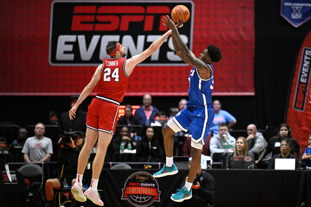Dayton forward Jacob Conner (24) blocks a shot by BYU guard Kennard Davis Jr., right, during the first half of an NCAA college basketball game, Friday, Nov. 28, 2025, in Kissimmee, Fla. (AP Photo/Phelan M. Ebenhack)