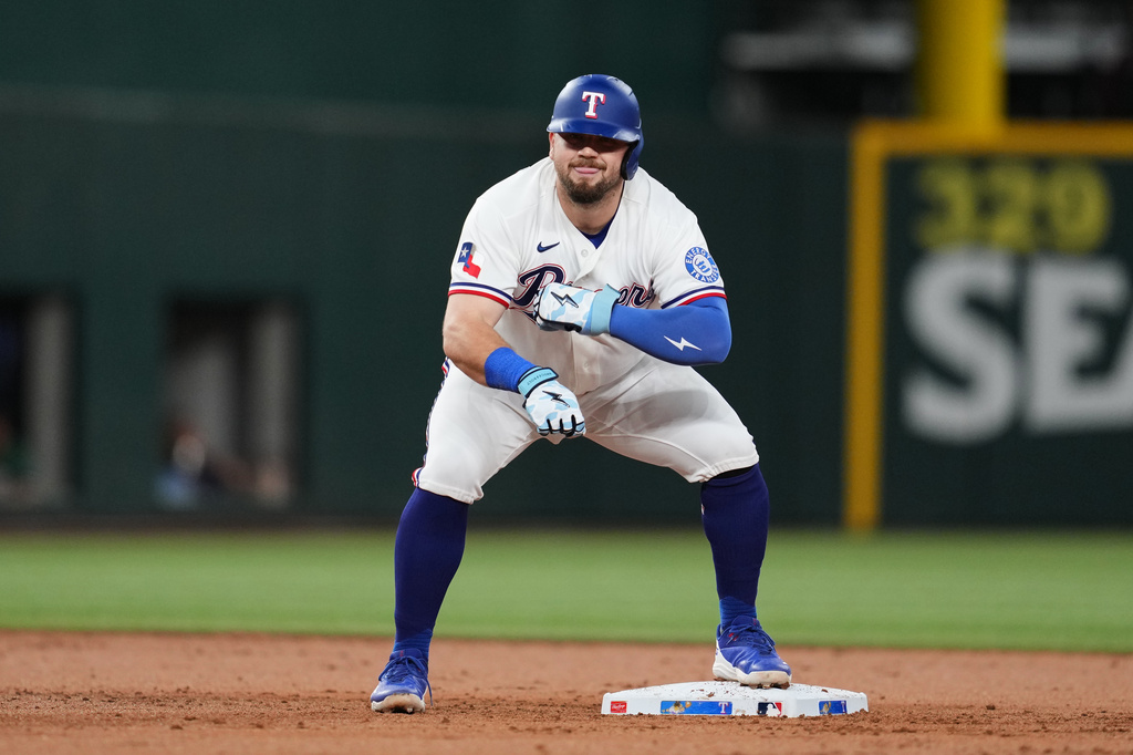 Texas Rangers' Jake Burger celebrates his ground-rule double that scored Justin Foscue in the first inning of a baseball game against the Boston Red Sox Wednesday, Sept. 16, 2026, in Arlington, Texas. (AP Photo/Tony Gutierrez)