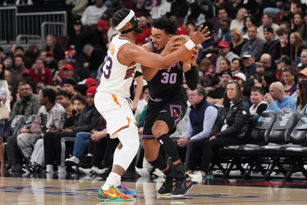 Phoenix Suns guard Jordan Goodwin, left, defends Chicago Bulls guard Tre Jones during the first half of an NBA basketball game in Chicago, Sunday, April 5, 2026. (AP Photo/Nam Y. Huh)