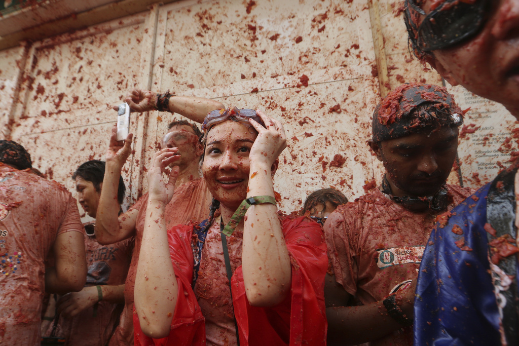 Revelers throw tomatoes at each other during the annual "Tomatina" tomato fight fiesta, in the village of Bunol near Valencia, Spain, Wednesday, Aug. 27, 2025. (AP Photo/Alberto Saiz)