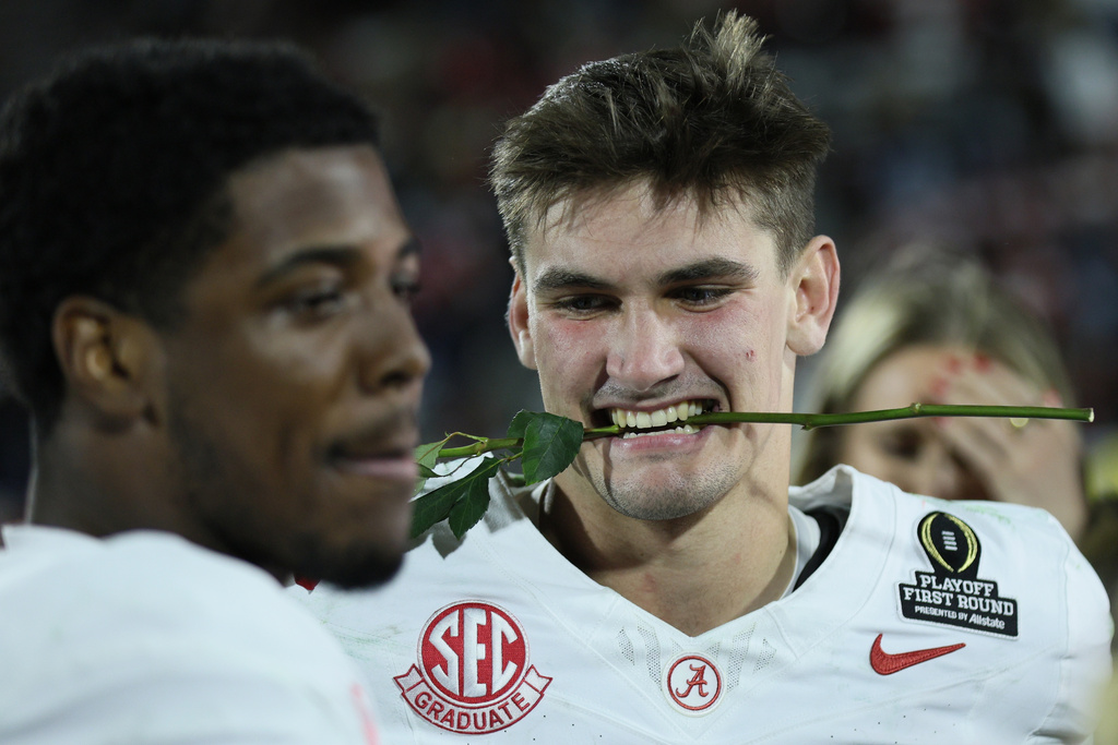 Alabama' Ty Simpson, right, and Germie Bernard celebrate a win after the first round of an NCAA College Football Playoff against Oklahoma, Saturday, Dec. 20, 2025, in Norman, Okla. (AP Photo/Nate Billings)