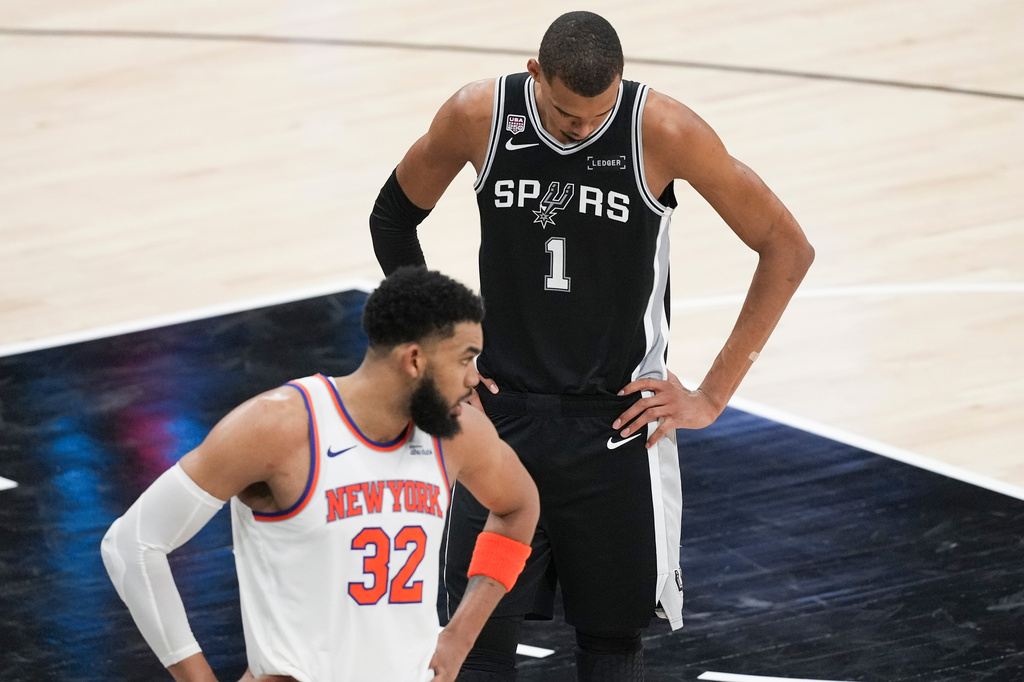 San Antonio Spurs forward Victor Wembanyama (1) looks down as New York Knicks center Karl-Anthony Towns (32) looks towards his bench during the second half of Game 1 of the NBA Finals basketball series, Wednesday, June 3, 2026, in San Antonio. (AP Photo/Eric Gay)