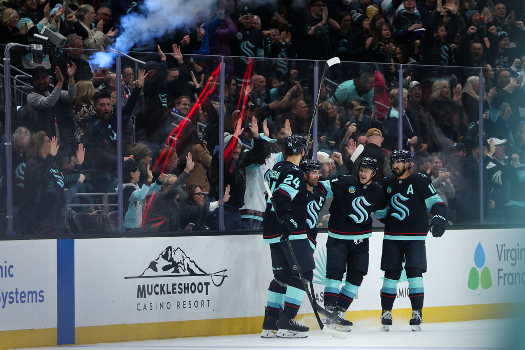 Members of the Seattle Kraken gather around Seattle Kraken right wing Jordan Eberle (7) after scoring a goal in the second period against the Vancouver Canucks during an NHL hockey game Saturday, Feb. 28, 2026, in Seattle. (AP Photo/Kevin Ng)