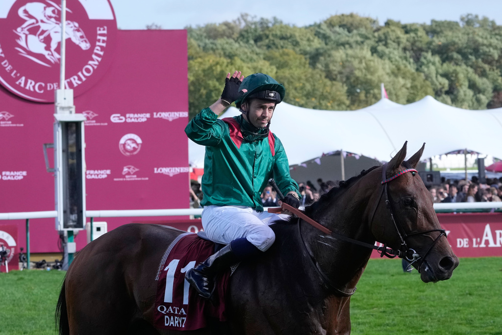 Mickael Barzalona , riding Daryz, waves after winning the Qatar Arc de Triomphe horse race, Sunday, Oct. 5, 2025 in Paris. (AP Photo/Michel Euler)