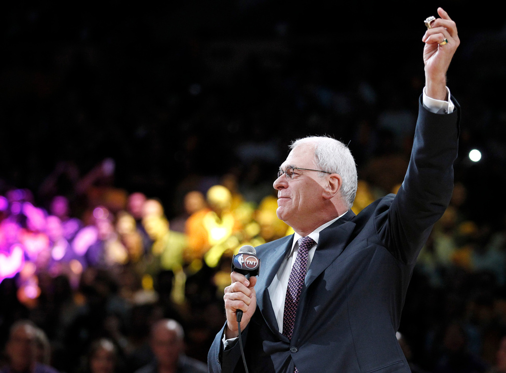 FILE - Los Angeles Lakers coach Phil Jackson holds up his NBA championship ring during a ceremony before the Lakers' basketball game against the Houston Rockets, in Los Angeles, Oct. 26, 2010. (AP Photo/Chris Carlson, File)