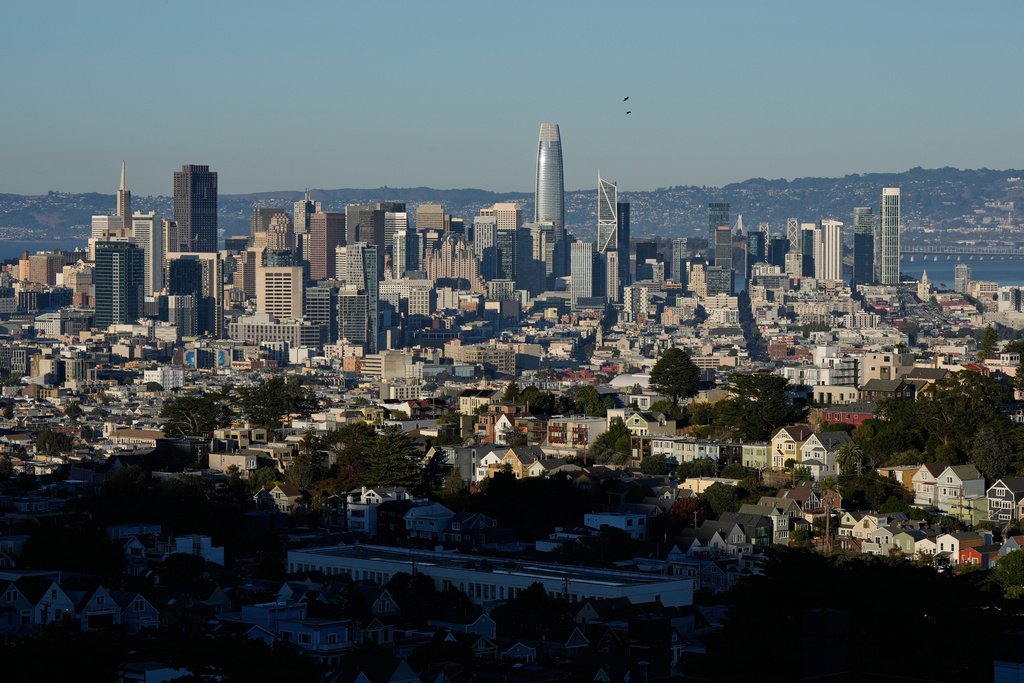 Homes are illuminated by sunlight as the San Francisco skyline is seen in the background, Friday, Oct. 17, 2025, in San Francisco. (AP Photo/Godofredo A. Vásquez)