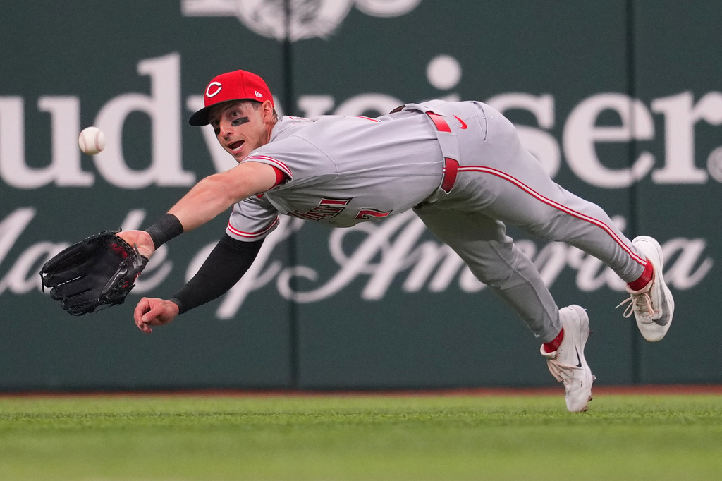 Cincinnati Reds left fielder Spencer Steer makes a diving attempt on a two-run double by Texas Rangers catcher Danny Jansen during the second inning of the Rangers' home-opener baseball game Friday, April 3, 2026, in Arlington, Texas. (AP Photo/Julio Cortez)