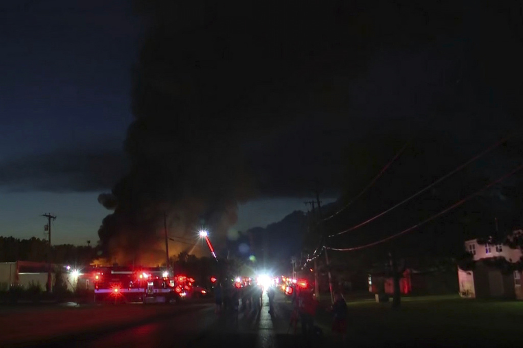 This image taken from video provided by WTVG shows firefighters working on the scene after an explosion at an industrial recycling business in Toledo, Ohio, Tuesday, Aug. 18, 2026. (WTVG via AP)