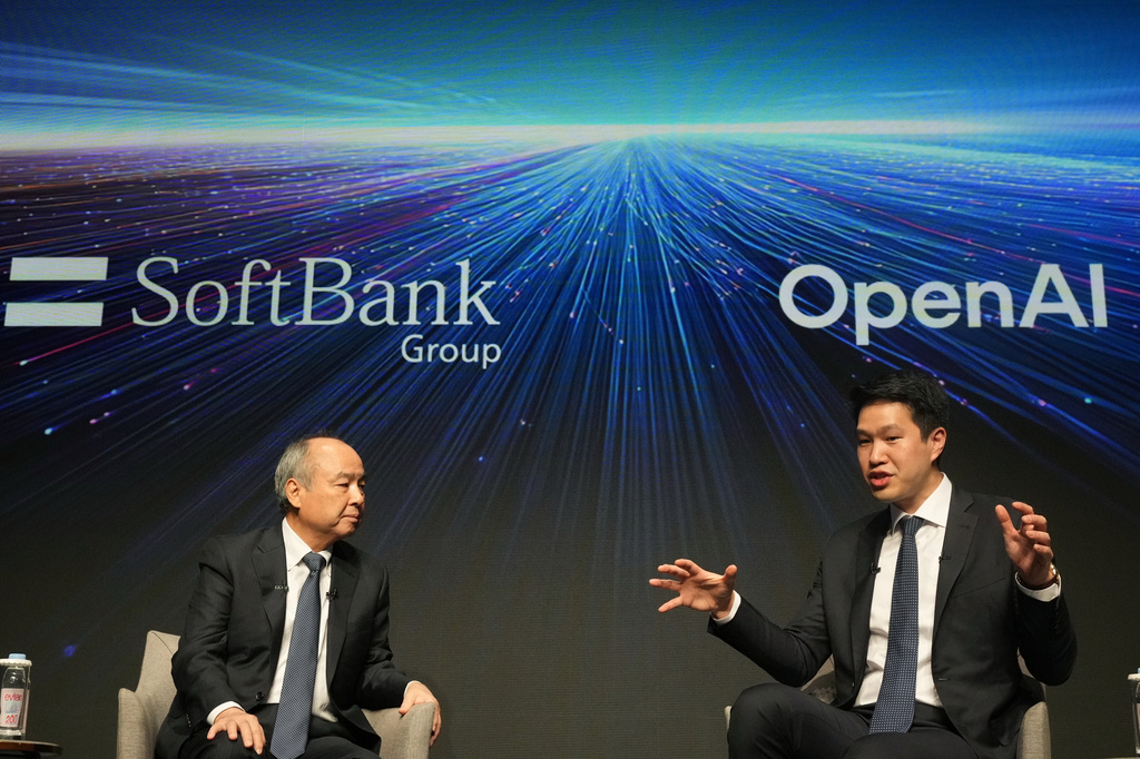 Masayoshi Son, left, chairman and CEO of SoftBank Group, listens to Mark Chen, chief research officer for OpenAI, during a talk at their business event in Tokyo, Tuesday, June 16, 2026. (AP Photo/Hiro Komae)