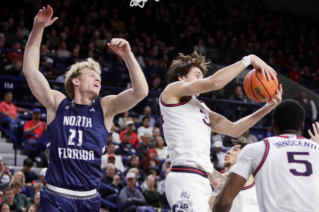 Gonzaga forward Braden Huff, second from left, grabs a rebound next to North Florida forward Dalton Gayman (21) during the first half of an NCAA college basketball game, Sunday, Dec. 7, 2025, in Spokane, Wash. (AP Photo/Young Kwak)