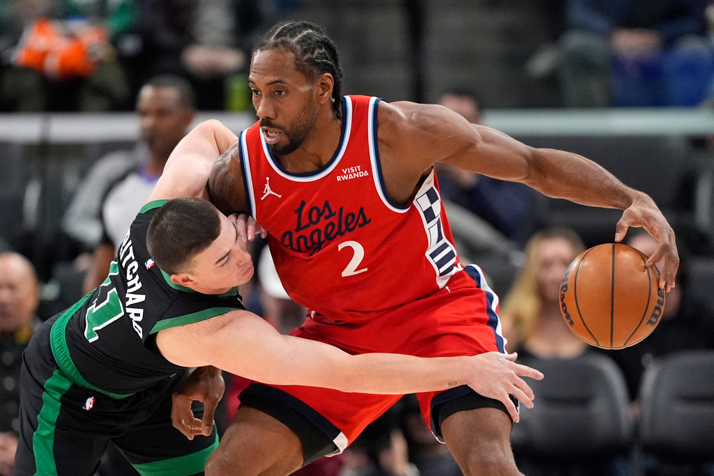 Boston Celtics guard Payton Pritchard, left, reaches in on Los Angeles Clippers forward Kawhi Leonard during the first half of an NBA basketball game Saturday, Jan. 3, 2026, in Inglewood, Calif. (AP Photo/Mark J. Terrill)