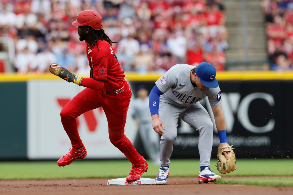 Cincinnati Reds' Jose De La Cruz, left, runs past Chicago Cubs second baseman Nico Hoerner, right, on a missed ball during the first inning of a baseball game, Saturday, July 11, 2026, in Cincinnati. (AP Photo/Jay LaPrete)
