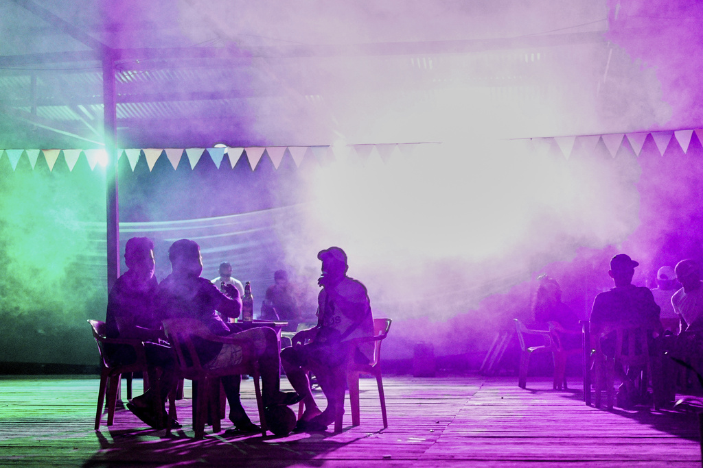 Patrons gather at a bar in Santa Rosa, Peru, an island on the Amazon River at the triple border with Colombia and Brazil, Sunday, Aug. 17, 2025. (AP Photo/Ivan Valencia)