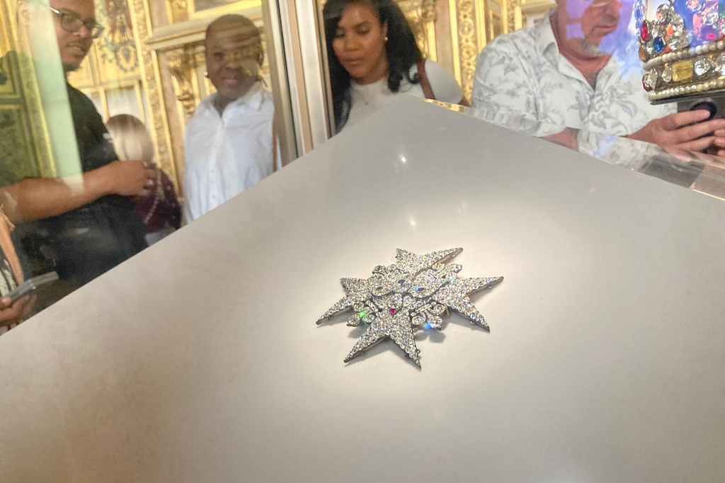 Visitors check jewelry in the Apollo Gallery of the Louvre museum on Sept. 4, 2025 in Paris. (AP Photo/Alexander Turnbull)
