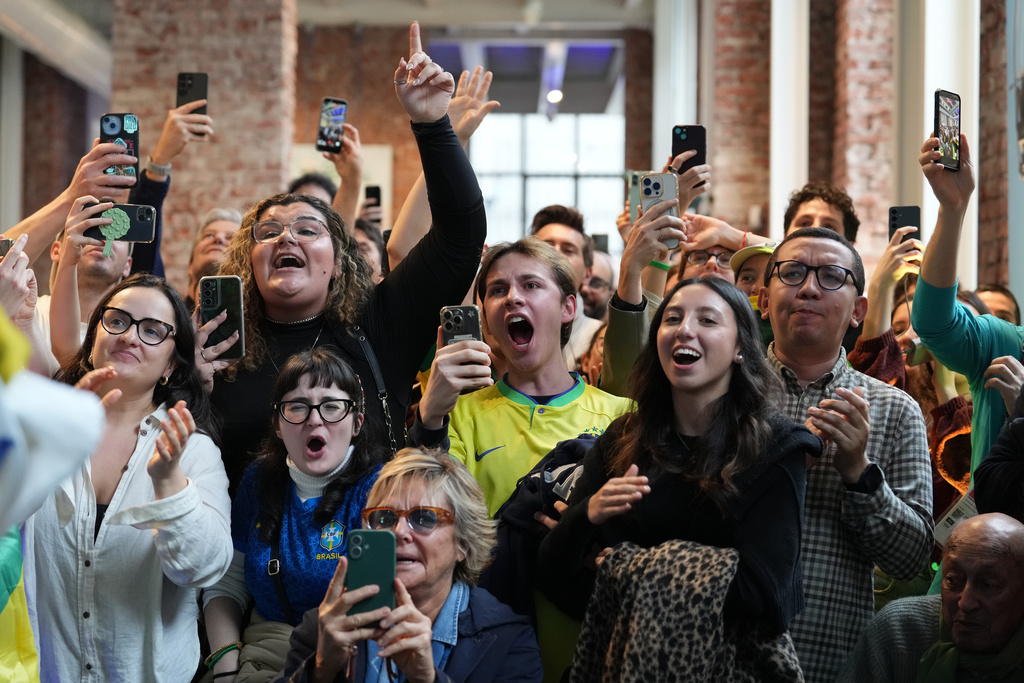 Supporters of Brazil's Lucas Pinheiro Braathen react at the Brazil House as he starts his second run in the men's giant slalom at the 2026 Winter Olympics, in Milan, Italy, Saturday, Feb. 14, 2026. (AP Photo/Antonio Calanni)