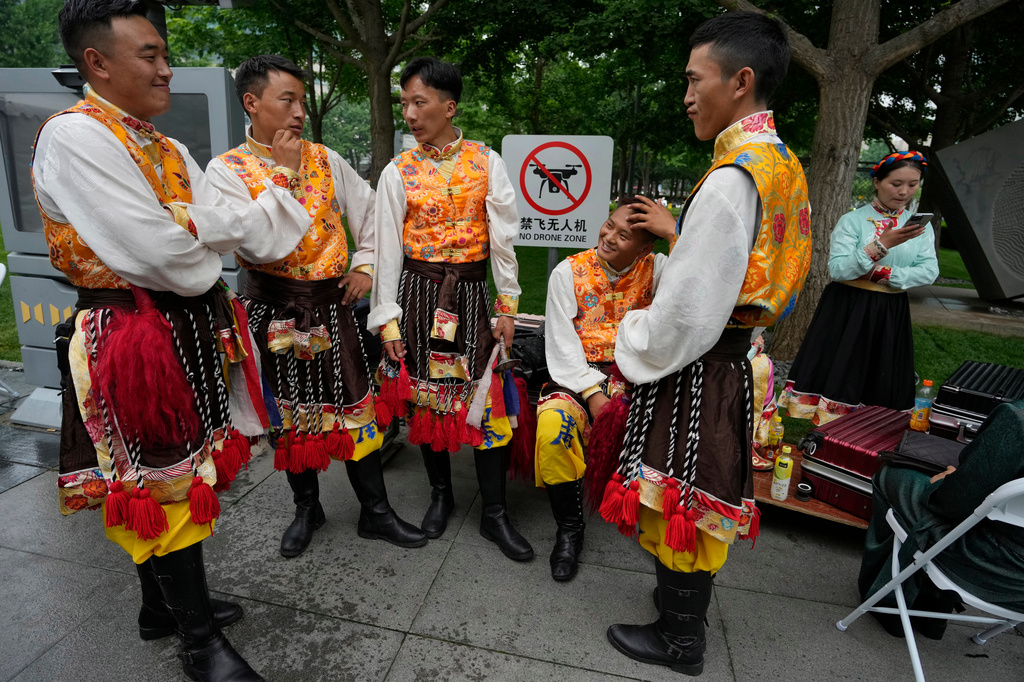 Performers rest near a "No Drone Zone" sign in Beijing, on May 31, 2023. (AP Photo/Ng Han Guan)
