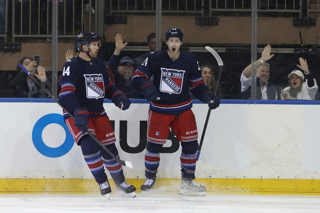 New York Rangers' Vladislav Gavrikov, left, and Tye Kartye, right, react after Kartye scored during the first period of an NHL hockey game against the Vancouver Canucks Sunday, Oct. 11, 2026, in New York. (AP Photo/Pamela Smith)