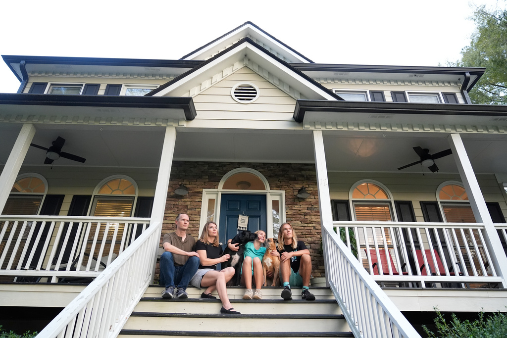 Meaghan and Chris Marr pose with their children and dogs for a photograph on Thursday, Sept. 25, 2025, in Cartersville, Ga. (AP Photo/Brynn Anderson)