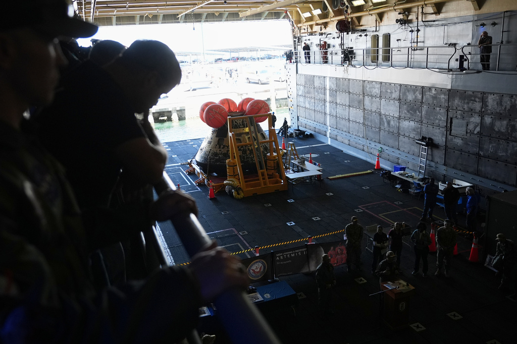 Crew members of the USS John P. Murtha join NASA and U.S. Navy officials as they gather in front of the Artemis II capsule in the bay area before docking at Naval Base San Diego, Saturday, April 11, 2026, in San Diego. (AP Photo/Gregory Bull)