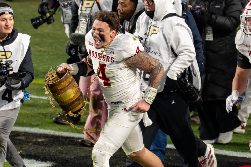 Indiana linebacker Aiden Fisher (4) celebrates with the Old Oaken Bucket trophy after an NCAA college football game against Purdue, Friday, Nov. 28, 2025, in West Lafayette, Ind. (AP Photo/Doug McSchooler)